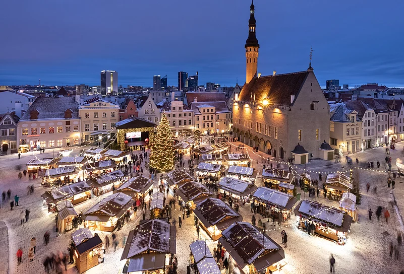 Tallinn Old Town Christmas market glowing with lights and snow