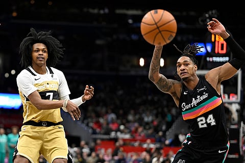 Washington Wizards guard Bub Carrington, left, passes the ball against San Antonio Spurs guard Devin Vassell (24) during the first half of an NBA basketball game in Washington.