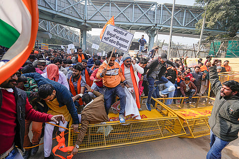 Vishwa Hindu Parishad (VHP) and Bajrang Dal members walk over barricades during a protest near the Bangladesh High Commission over attacks on Hindus in the neighbouring country, in New Delhi.