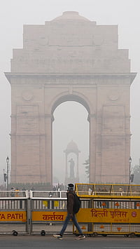 | Photo: PTI/Arun Sharma : A man walks by as the India Gate remains shrouded in fog on a winter morning, in New Delhi.