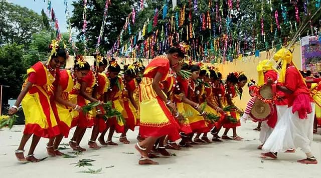 Folk dancers in traditional attire performing Karma Naach or a similar festival dance