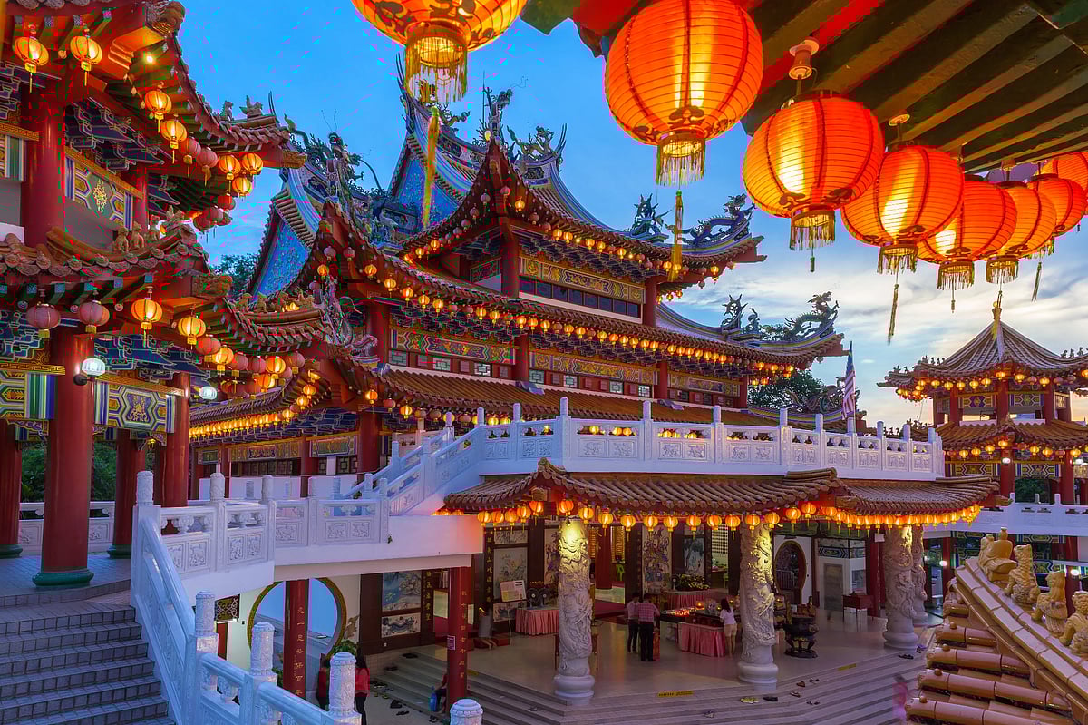 Ornate Chinese temple  illuminated by glowing orange lanterns and decorative lights