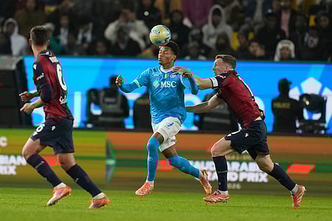 Napoli's David Neres, center, and Bologna's Lewis Ferguson vie for the ball during the Italian Super Cup final soccer match between Napoli and Bologna in Riyadh, Saudi Arabia.