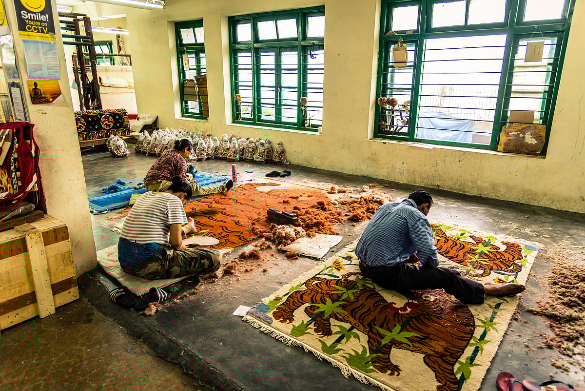 Colourful paintings carpet are being prepared for sale by Indian rural Tibetan worker. Handicrafts are rural Industry in Himachal Pradesh.  - Shutterstock
