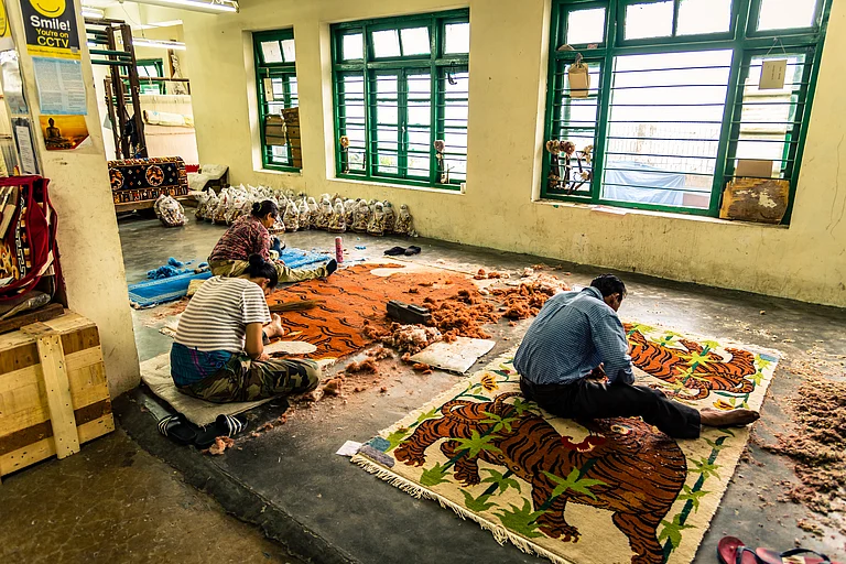 Colourful paintings carpet are being prepared for sale by Indian rural Tibetan worker. Handicrafts are rural Industry in Himachal Pradesh. - Shutterstock