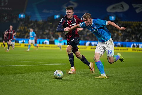 Napoli's Rasmus Hojlund, right, and Bologna's Tommaso Pobega vie for the ball during the Italian Super Cup final soccer match between Napoli and Bologna in Riyadh, Saudi Arabia.