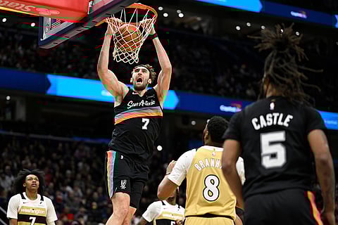 San Antonio Spurs center Luke Kornet (7) dunks during the second half of an NBA basketball game against the Washington Wizards, in Washington.