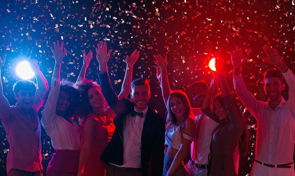 Friends celebrating at a party with falling confetti