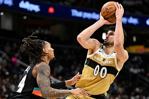 Washington Wizards forward Tristan Vukcevic (00) looks to score over San Antonio Spurs guard Devin Vassell, left, during the first half of an NBA basketball game in Washington. 