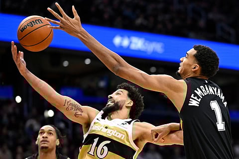 Washington Wizards forward Anthony Gill (16) grabs a rebound against San Antonio Spurs forward Victor Wembanyama (1) during the first half of an NBA basketball game in Washington. 