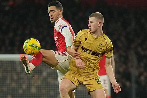 Arsenal's Mikel Merino, left, and Crystal Palace's Adam Wharton fight for the ball during the English Football League Cup quarter-final soccer match between Arsenal and Crystal Palace in London.