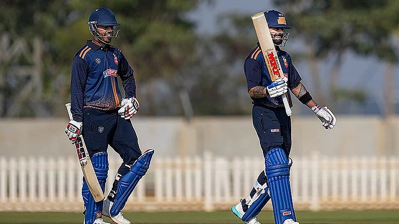 Virat Kohli, right, celebrates his century during the Vijay Hazare Trophy 2025-26 cricket match between Andhra and Delhi, at BCCI Centre of Excellence Ground, in Bengaluru. - PTI