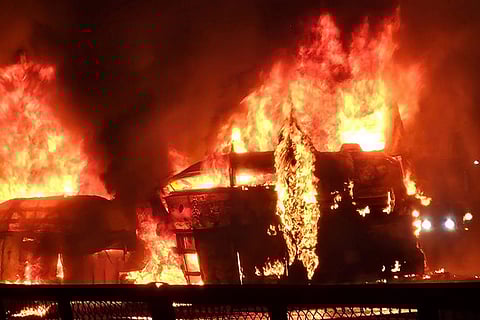 Flames and smoke billow out after a bus caught fire following a collision with a speeding truck, in Chitradurga. At least nine persons were killed in the incident.