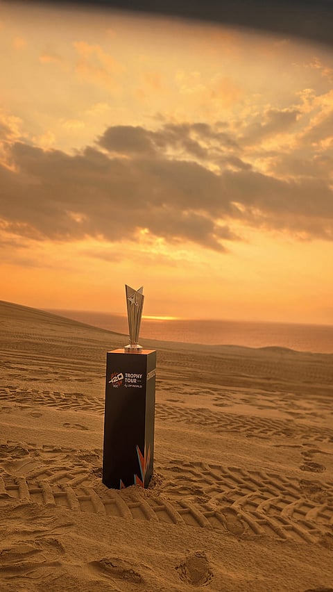 The ICC Men’s T20 World Cup 2026 trophy on display at sunset across the desert during the trophy tour in Qatar