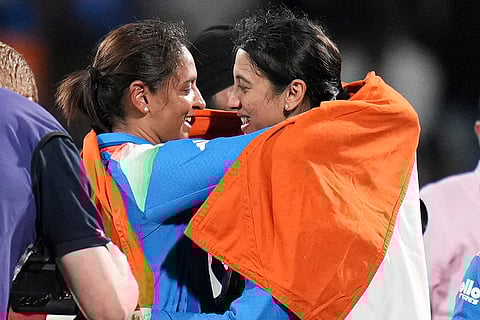 India’s captain Harmanpreet Kaur, left, and vice captain Smriti Mandhana hold the Indian tricolour as they celebrates after winning the ICC Women's World Cup final ODI cricket match between India Women and South Africa Women, at the DY Patil Stadium, in Navi Mumbai, Sunday, Nov. 2, 2025.