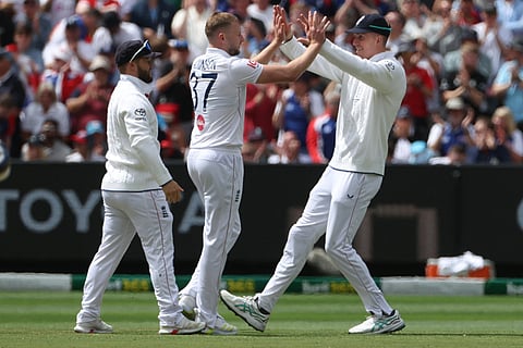 England's Gus Atkinson, center, celebrates with teammates after bowling Australia's Travis Head during their Ashes cricket test match in Melbourne.