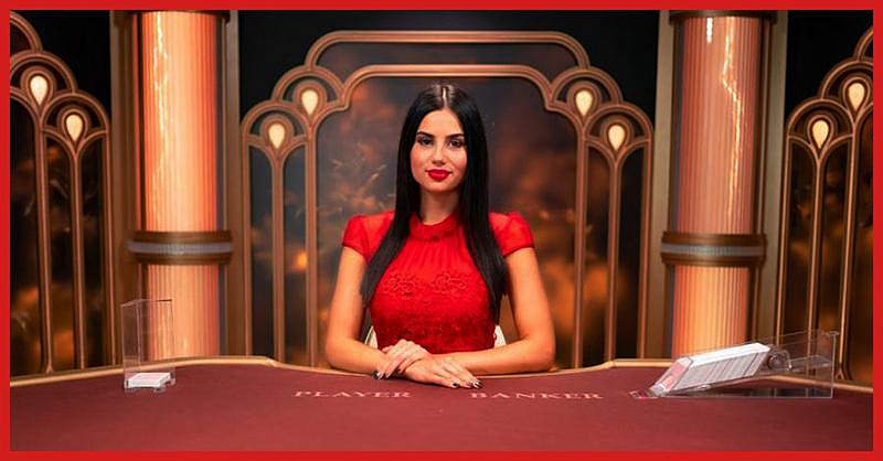 Live casino dealer in red dress at a baccarat table