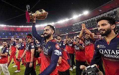 Royal Challengers Bengaluru’s Virat Kohli holds the Indian Premier League (IPL) 2025 championship trophy during the team's victory lap at the Narendra Modi Stadium, in Ahmedabad, Tuesday, June 3, 2025. 