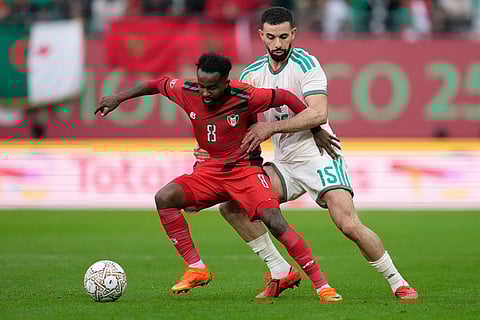Sudan's Abdelrazig Omer, left, challenges for the ball with Algeria's Rayan Aït-Nouri during the Africa Cup of Nations group E soccer match between Algeria and Sudan in Rabat, Morocco.