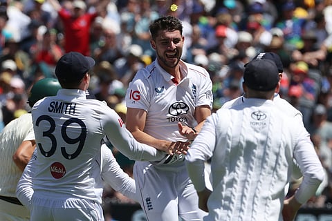 England's Josh Tongue, center, celebrates with teammates after taking the wicket of Australia's Scott Boland during their Ashes cricket test match in Melbourne.