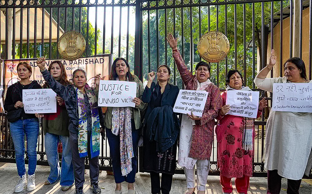 Agitators, including women activists, hold placards as they stage a protest against the suspension of the jail term of Kuldeep Sengar, a former BJP MLA who was convicted in the Unnao rape case, outside the Delhi High Court, in New Delhi. - | Photo: PTI/Salman Ali