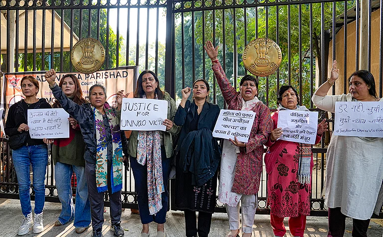 Agitators, including women activists, hold placards as they stage a protest against the suspension of the jail term of Kuldeep Sengar, a former BJP MLA who was convicted in the Unnao rape case, outside the Delhi High Court, in New Delhi. - | Photo: PTI/Salman Ali