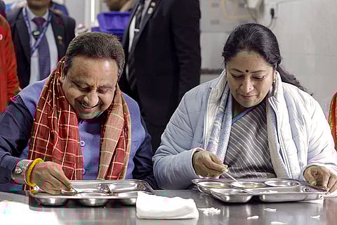 Delhi Chief Minister Rekha Gupta, right, with BJP leader Praveen Khandelwal eats a meal at an Atal Canteen during it's inauguration ceremony, in Shalimar Bagh, New Delhi. 
