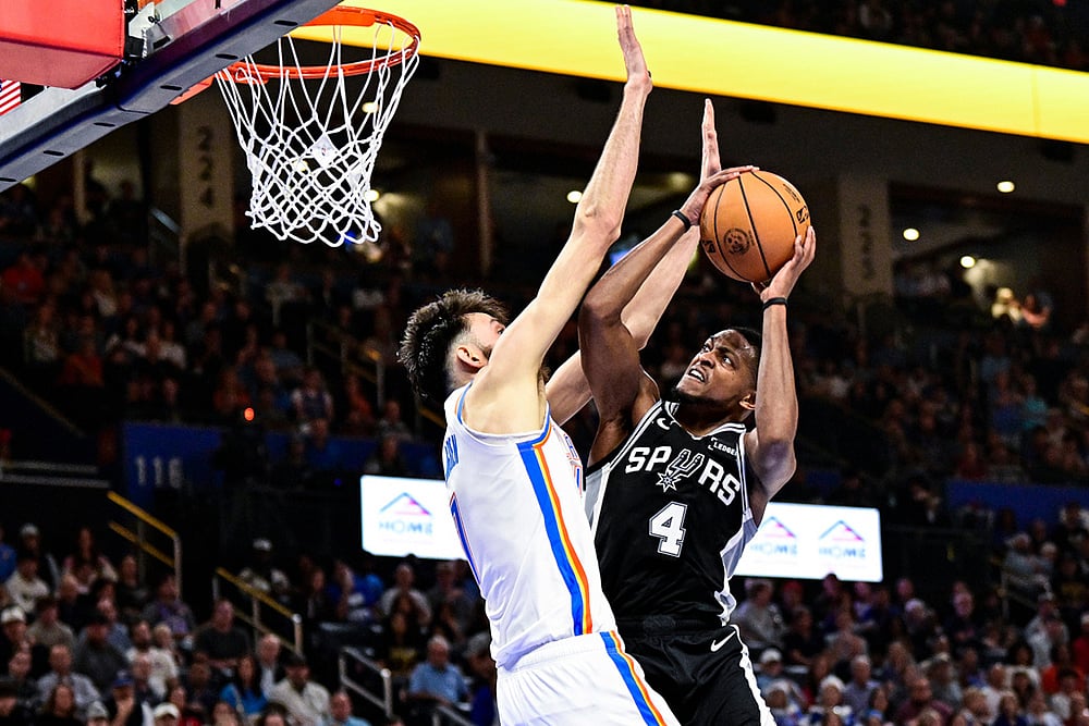 San Antonio Spurs guard De'Aaron Fox (4) shoots against Oklahoma City Thunder Chet Holmgren (7) during the first half of an NBA basketball game in Oklahoma City.  - | Photo: AP/Gerald Leong