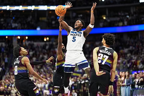 Minnesota Timberwolves guard Anthony Edwards, foreground center, is fouled by Denver Nuggets guard Tim Hardaway Jr., back center, as Denver Nuggets guards Peyton Watson, left, and Jamal Murray cover in the second half of an NBA basketball game in Denver. 