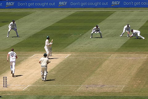 England's Harry Brook, right, catches out Australia's Alex Carey, center, on Day 2 of their Ashes cricket test match in Melbourne.