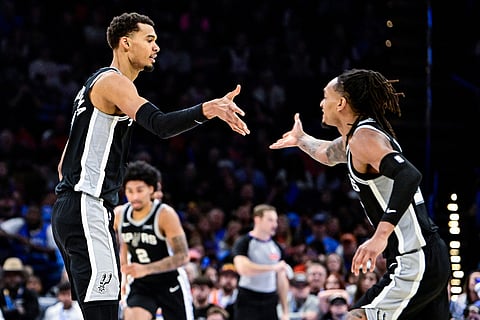 San Antonio Spurs forward/center Victor Wembanyama (1) celebrates with San Antonio Spurs guard/forward Devin Vassell (24) during the second half of an NBA basketball game, in Oklahoma City. 