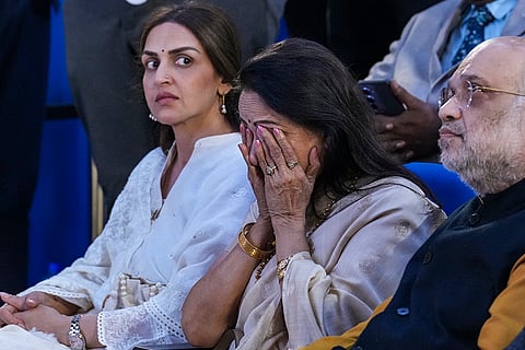 Bollywood actor and BJP MP Hema Malini gets emotional during the prayer meeting of late actor Dharmendra, in New Delhi, Thursday, Dec. 11, 2025. Union Home Minister Amit Shah, right, and Hema Malini’s daughter Esha Deol are also seen.