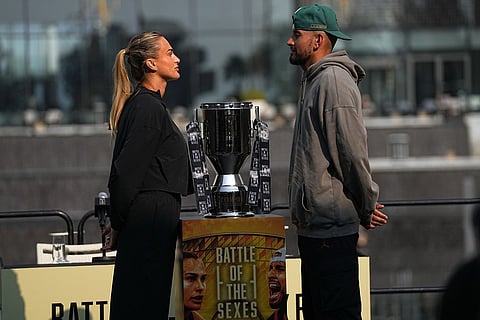Tennis players Aryna Sabalenka of Belarus, left, and Nick Kyrgios of Australia face-off with the trophy during a press conference ahead of the Battle of the Sexes exhibition match at Atlantis The Royal in Dubai, United Arab Emirates.