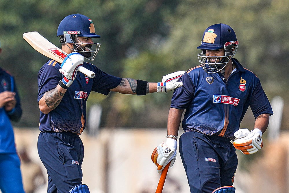 Delhi's captain Rishabh Pant, right, with teammate Virat Kohli during the Vijay Hazare Trophy 2025-26 cricket match between Gujarat and Delhi, at BCCI Centre of Excellence Ground, in Bengaluru. - | Photo: PTI/Shailendra Bhojak