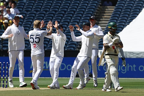 England's Ben Stokes, second left, is congratulated by teammates after taking the wicket of Australia's Jake Weatherald, right, on Day 2 of their Ashes cricket test match in Melbourne.