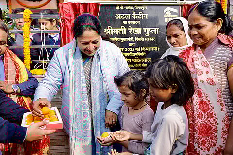 Delhi Chief Minister Rekha Gupta distributes sweets during the inauguration ceremony of an Atal Canteen, in Pitampura, New Delhi. 