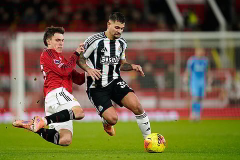 Manchester United's Manuel Ugarte, left, fights for the ball with Newcastle's Bruno Guimaraes during the English Premier League soccer match between Manchester United and Newcastle in Manchester, England.
