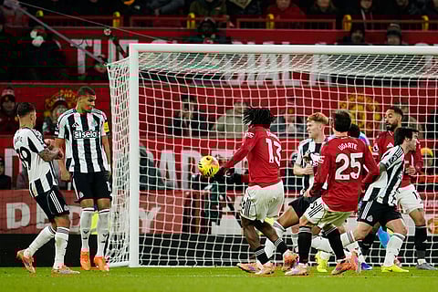 Manchester United's Patrick Dorgu, center left, scores the opening goal during the English Premier League soccer match between Manchester United and Newcastle in Manchester, England.
