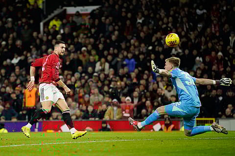 Manchester United's Diogo Dalot, left, makes an attempt on goal as Newcastle's goalkeeper Aaron Ramsdale reaches out for a save during the English Premier League soccer match between Manchester United and Newcastle in Manchester, England.