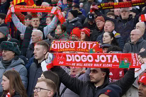 Liverpool fans sing and hold up scarves prior to the English Premier League soccer match between Liverpool and Wolverhampton Wanderers in Liverpool.