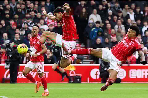 Nottingham Forest's Morgan Gibbs-White and Igor Jesus jump for the ball during the Premier League match between Nottingham Forest and Manchester City, in Nottingham, England.