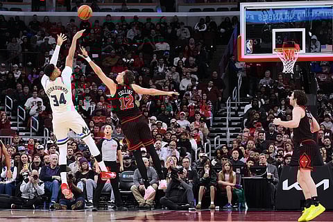 Milwaukee Bucks forward Giannis Antetokounmpo, left, shoots over Chicago Bulls forward Zach Collins (12) during the second half of an NBA basketball game in Chicago, Saturday, Dec. 27, 2025. ()