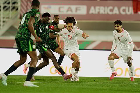 Tunisia's Hannibal Mejbri, center, is challenged by Nigeria's Wilfred Ndidi during the Africa Cup of Nations group C soccer match between Nigeria and Tunisia in Fez, Morocco.