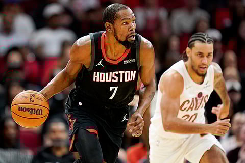 Houston Rockets forward Kevin Durant (7) dribbles against the Cleveland Cavaliers during the first half of an NBA basketball game in Houston.