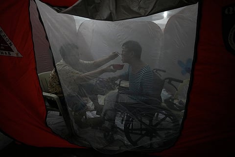 Judy Bertuso, left, feeds her husband Apollo inside a tent at an evacuation center as Typhoon Fung-wong enters the country Nov. 9, 2025, in Quezon city, Philippines.