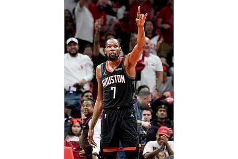 Houston Rockets forward Kevin Durant reacts after making a basket against the Cleveland Cavaliers during the second half of an NBA basketball game in Houston.