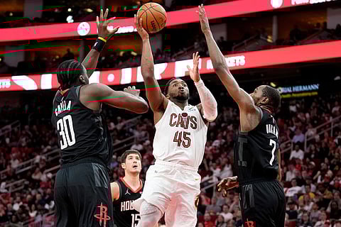 Cleveland Cavaliers guard Donovan Mitchell (45) shoots as Houston Rockets center Clint Capela (30) and forward Kevin Durant defend during the second half of an NBA basketball game in Houston.