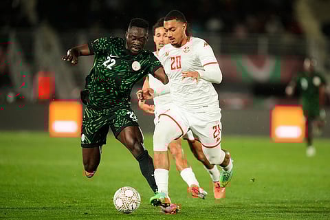 Nigeria's Akor Adams, left, battles for the ball with Tunisia's Yan Valery during the Africa Cup of Nations group C soccer match between Nigeria and Tunisia in Fez, Morocco.
