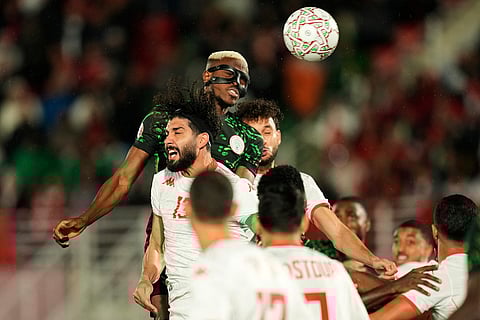 Nigeria's Victor Osimhen, top, wins a header against Tunisia's Ferjani Sassi during the Africa Cup of Nations group C soccer match between Nigeria and Tunisia in Fez, Morocco.