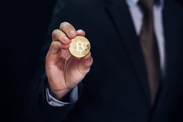 A man holding a Bitcoin coin